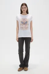 Remera blanca de algodón, de manga corta con vuelta, corte holgado y estampado frontal con motivos de mariposa, flores y texto de estilo retro.