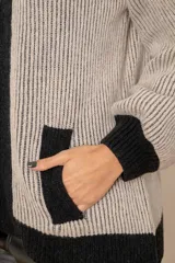 Campera de punto en lambswool, con diseño bicolor en beige y negro. Presenta cuello polo, cierre frontal con doble cursor, mangas largas con puños ajustados y bolsillos laterales.