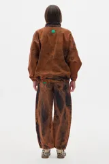 Campera estilo olímpica de jean color marrón con efecto lavado. Corte oversized, con elástico en la cintura, cuello alto y bolsillos al frente con cierre.