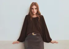 Blusa de manga larga color marrón oscuro con escote redondo y frunces frontales.