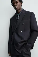 Blazer de corte regular fit confeccionada en tejido de lana italiana. Presenta cuello con solapas de pico, cierre frontal de botonadura cruzada, bolsillo de vivo en el pecho y bolsillos con solapa en la cadera.