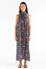 Vestido largo negro con cuello halter y estampado exclusivo de pequeños círculos y peces. Diseño sin mangas y corte fluido.