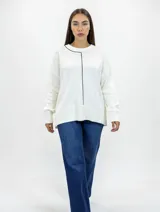 Buzo de tejido de punto color blanco, con cuello redondo y detalle de línea vertical en contraste color negro. Presenta corte relajado, mangas largas con puños acanalados y ruedo amplio con terminación acanalada.