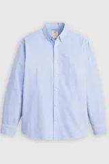 Camisa celeste de manga larga con cuello abotonado y cierre frontal de botones. Confeccionada en algodón con sutil bordado en el pecho.