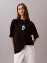 Remera de corte oversize confeccionada en algodón, con cuello redondo y mangas cortas. Presenta un estampado frontal con el logo de la marca en disposición vertical.
