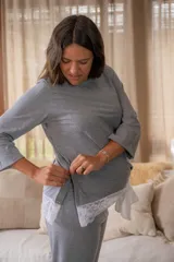Pijama maternal gris con remera de manga larga con botones a los costados para amamantar y detalle de puntilla en el ruedo. Pantalón con calce maternal, elástico suave y lazo para ajustar la cintura.