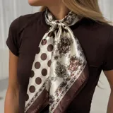 Pañuelo de satén con diseño dividido en dos mitades, una con estampado de lunares marrones sobre fondo beige y la otra con un patrón ornamental detallado.
