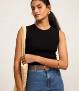 Blusa sin mangas color beige confeccionada en tejido de punto con textura acanalada y cuello redondo.