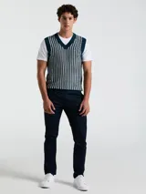 Chaleco de punto con escote en V, color azul marino con rayas verticales blancas y logo bordado en el pecho.