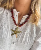 Collar corto con cuentas de piedra color ladrillo y detalles dorados. Dije grande de estrella de mar dorada con textura irregular.