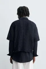 Camiseta de tejido de punto crochet con estructura abierta, color azul marino. Presenta cuello redondo y mangas cortas.