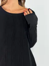 Blusa de manga larga en color blanco, con cuello redondo y detalle de alforzas verticales en el frente. Presenta un corte holgado y fluido.