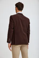 Blazer de pana color marrón oscuro, con cierre frontal de dos botones, solapas clásicas y bolsillos laterales con solapa. Presenta un diseño estructurado y elegante.