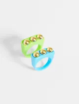 Set de dos anillos de resina, uno color verde con tres tachas doradas y otro color celeste.
