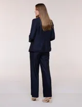 Blazer de sastre entallado color gris claro, con solapa de muesca clásica, cierre frontal de un solo botón y bolsillos frontales de vivo horizontales.