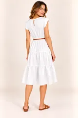 Vestido midi color blanco, de corte acampanado con diseño escalonado en la falda, mangas cortas con volados y detalle de cinto ajustable a rayas en la cintura.