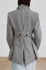 Blazer Zara Woman Collection de corte asimétrico con estampado de cuadros vichy en blanco y negro. Presenta cuello solapa, cierre frontal con botones y un diseño de bajo irregular con abertura central.