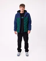 Campera con capucha, diseño bicolor en negro y gris oscuro, con panel frontal acolchado y mangas lisas. Cuenta con cierre frontal, bolsillos laterales y puños elásticos.