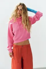 Pantalón cargo oversize de tiro medio color rojo, con bolsillos laterales y de plastrón, y lazadas ajustables en la cintura.