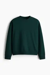 Buzo de cuello redondo color verde oscuro, confeccionado en mezcla de algodón con interior suave. Presenta hombros caídos, mangas largas y puños y bajo con ribete acanalado.