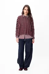 Sweater de punto con diseño de rayas verticales en relieve y textura trenzada, color terracota y beige. Presenta cuello redondo, corte holgado y diseño cropped.