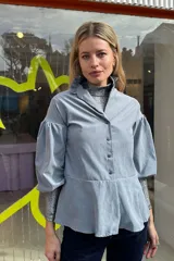 Camisa celeste con cuello mao con volados, mangas abullonadas 3/4 y corte peplum.