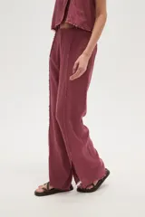 Pantalon de corte recto confeccionado en viscosa, con costuras frontales decorativas con efecto desflecado y aberturas en el ruedo.