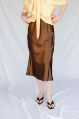Falda midi color marrón de satén al bies con cintura elástica.