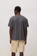 Remera de algodón color gris oscuro, con cuello redondo, mangas cortas y detalle de bordado pequeño en forma de cruz en el centro del pecho.