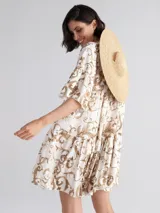 Vestido corto con estampado de arabescos color beige y marrón, escote en V y mangas cortas.