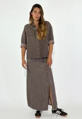 Chaqueta color crudo con cuello camisero, cierre frontal con botones, mangas 3/4 con puños arremangados y dos bolsillos de parche en el pecho.