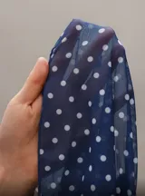 Top negro con lunares blancos, escote en V y breteles finos.