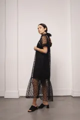 Vestido largo color ocre con estampado de cuadrados dorados, cuello alto y corte amplio. Incluye viso liso al tono.