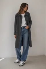 Sacon de paño gris oscuro con detalles en tejido fantasía texturizado en cuello, puños y bolsillos. Presenta cierre frontal con botones y corte recto.