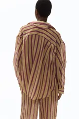 Camisa H&M de corte oversized en mezcla de lyocell, con estampado de rayas verticales en tonos bordó, beige y verde oliva. Presenta cuello camisero, abertura frontal con botones, hombros caídos y mangas largas con puños abotonados.