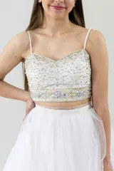 Vestido largo de tul color blanco, con escote bordado y falda con volados.