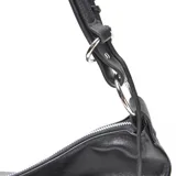 Cartera tipo hobo de cuero negro, con cierre superior, herrajes metálicos plateados y correa de hombro con detalle trenzado. Presenta el logo de la marca XL grabado en el frente.