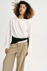 Jeans de tiro alto con pinzas delanteras, pernera ancha y fluida. Cuenta con cierre frontal de cremallera y botón, bolsillos frontales y bolsillos de plastrón en la parte trasera.