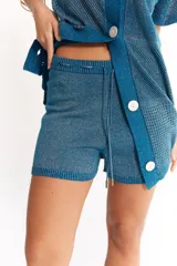 Short tejido de algodón con lurex, color celeste con brillo dorado, suelto, con cintura elástica y cordón para ajustar.