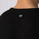 Remera oversize de lino entramado color blanco off-white, con cuello redondo, mangas cortas de hombro caído y etiqueta aplicada en el borde inferior.