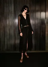 Vestido midi de gasa color negro, con cuello en V, manga larga abullonada y cierre delantero con botones. Incluye forro interior y diseño recto.