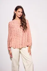 Blusa de corte oversize con estampado de abanicos, cuello redondo con pequeña abertura frontal, cierre de botones y mangas largas con puños elásticos.