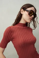 Top negro de manga corta tejido con textura acanalada, cuello alto y terminaciones onduladas.