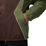 Campera rompevientos Nike Jordan con diseño color block en tonos marrón y verde oliva. Presenta cierre frontal completo, capucha ajustable, bolsillos laterales con cierre y logo Jumpman bordado en el pecho.