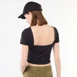 Camiseta corta de color negro, con ajuste al cuerpo, mangas cortas y escote cuadrado en la espalda.