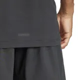 Remera deportiva Adidas de manga corta, color gris oscuro jaspeado, con cuello redondo y logo de la marca en tono oscuro en el pecho. Presenta detalles de costura en los hombros y aberturas en los dobladillos laterales.