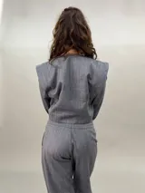 Campera corta de lana y seda color gris con cierre frontal oculto y mangas largas con diseño de tablas en los puños.