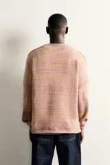 Jersey de punto con diseño de rayas horizontales en tonos tierra y violeta, de corte regular, cuello redondo y manga larga.