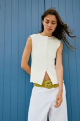 Top tipo chaleco confeccionado en hilatura con viscosa, con diseño de rayas horizontales en blanco y azul marino. Presenta cuello redondo, manga sisa y cierre frontal con botones.