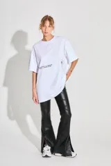 Remerón blanco de jersey 24/1 peinado, corte oversized, mangas cortas y ruedo ancho. Estampa serigrafiada en frente y espalda a contratono.